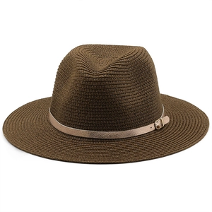 Detail of dark brown straw fedora hat featuring a premium gold metallic buckle band