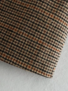Gros plan sur la texture du tissu en laine à carreaux marron et noir pour blazer