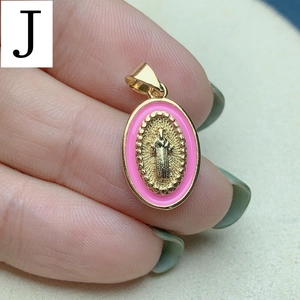 Macro shot of oval Jesus pendant with pink enamel border and golden metal relief