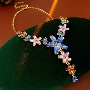 Détail du collier vintage avec fleurs en cristal coloré et pendentif goutte bleue