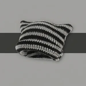 Close-up of black and white striped crochet knit hat featuring cute cat ear design