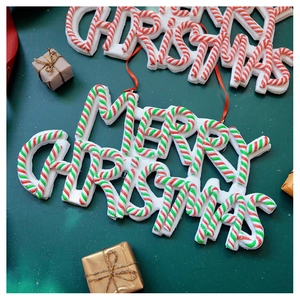 Close-up of Merry Christmas glitter foam tree ornaments on dark green background