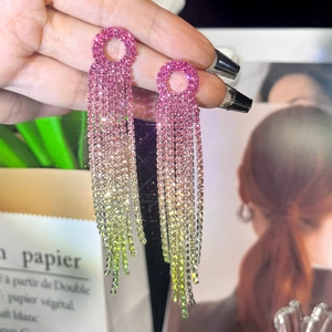 Close-up of pink and green gradient tassel earrings with shimmering rhinestones detail