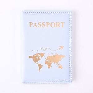 Close-up of light blue PU leather passport cover with gold world map and plane design