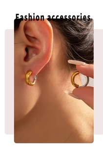 Close-up of geometric bicolor gold and silver titanium steel hoop earrings on model