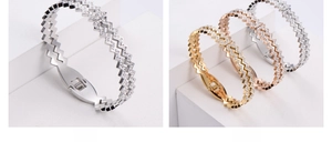 Macro shot of wave-shaped stainless steel bracelets with pavé rhinestones in three colors