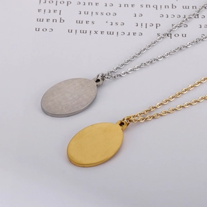 Detail of oval pendants with brushed metal texture in gold and silver finish