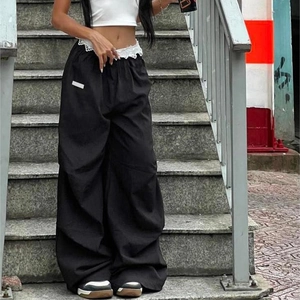 Détail du pantalon cargo large avec bordure en dentelle blanche à la taille contrastée