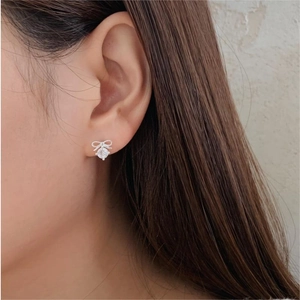 Macro side view of a 925 sterling silver bow earring with a sparkling round zircon