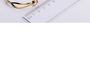 Macro view of gold wave cross bracelet showing the inlaid 1cm round crystal detail