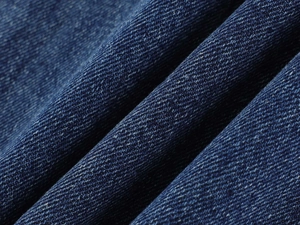 Macro detail of high-quality blue denim fabric showing twill weave and texture