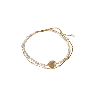 Elegant double-layered gold necklace with white pearls and a clear crystal pendant centerpiece