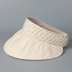 Detail of beige organza sun hat with black polka dots and tiered pleated fabric design