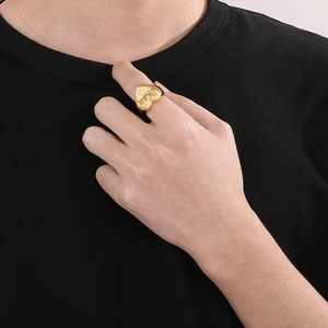 Primo piano di anello a cuore dorato con incisione Mom e finitura in metallo spazzolato