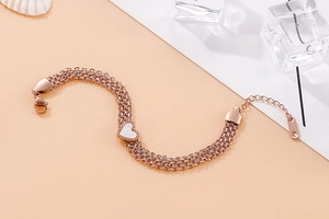Close-up of triple-layered rose gold stainless steel heart bracelet with shell inlay