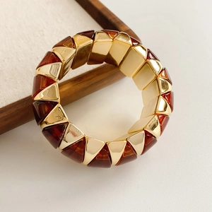 Detailed shot of amber resin prisms and gold metal blocks on an elastic bracelet
