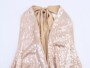 Detail of sequined halter top featuring back neck tie bow in champagne glitter fabric