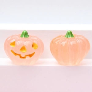 Detail showing two pink 3D luminous resin pumpkins with smiling faces for DIY crafts