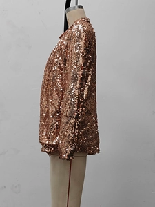 Detail of rose gold sequin jacket showing dense stitching and metallic reflective texture