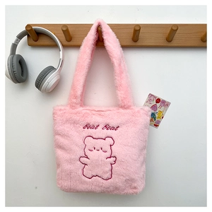 Détail du sac seau en peluche rose avec broderie ours mignonne et texture douce