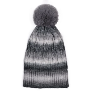 Detail of grey gradient cable knit beanie with faux fur pompom and ribbed cuff
