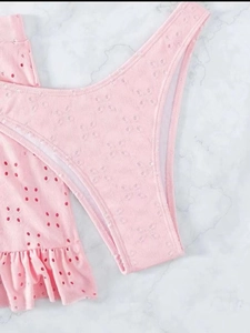 Detail van roze broderie-stof met ruches aan de randen op een strandbikini-set