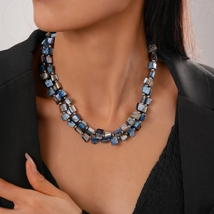 Close-up of double-layered blue shell bead necklace on neck for elegant summer vacation look