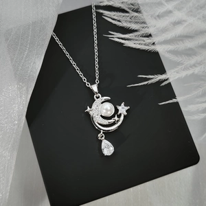 Silver star and moon necklace with pearl and teardrop gemstone on display card