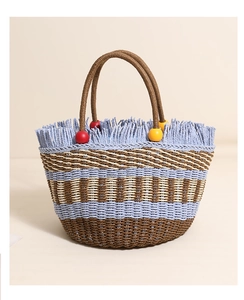 Close-up of blue fringe detail and wooden beads on a striped straw bucket bag