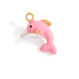Detailed close-up of a pink dolphin charm with gold-plated metal base and enamel finish