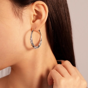 Close-up of stylish silver geometric hoop earrings featuring pavé cubic zirconia details