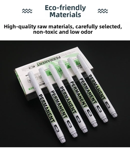 Detail of six white marker pens with 1.0mm nibs shown on black background with packaging
