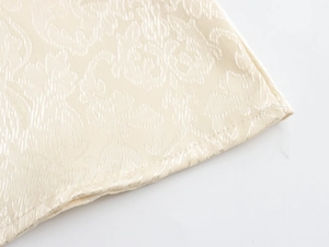 Détail macro du tissu jacquard gaufré beige avec des finitions de couture à volants
