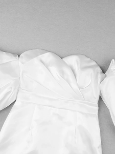 Detailed view of white satin off-the-shoulder dress with elegant puff sleeves and glossy fabric