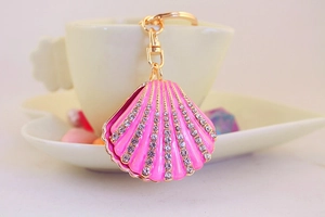 Detail of pink seashell keychain with gold metal edges and sparkling crystal rhinestones