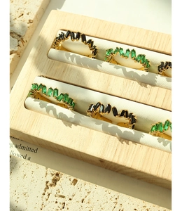 Detail of 18K gold plated rings with emerald green and black zircon in a jewelry box
