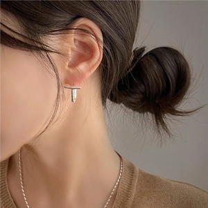 Minimalist 925 sterling silver T-shaped stud earrings worn by a model in a modern style