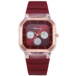 Detailed macro view of square rose gold metal case and burgundy silicone strap of the watch