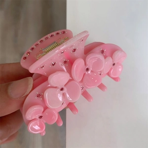 Detail of pink acetate flower hair claw clip with sparkling rhinestones decoration