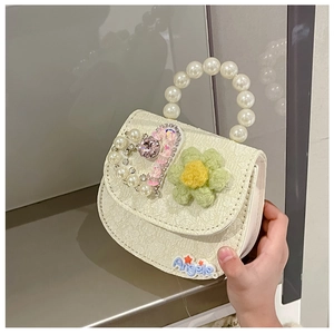 Detail of white pleated kids purse with pearl handle and floral heart accents