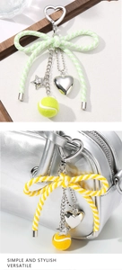 Detail of keychain with bow, metal star, heart charms and mini tennis ball on a bag