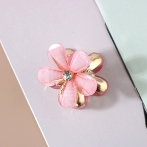 Macro shot of pink resin flower hair claw with glitter and sparkling center rhinestone