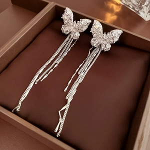 Detailed view of silver butterfly ear cuff with sparkling zircon and long chain tassels