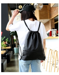 Detailed view of black drawstring backpack with honeycomb texture on a model