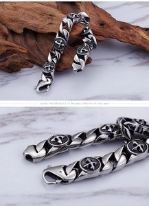 Macro detail of retro stainless steel cross bracelet with pirate compass charms