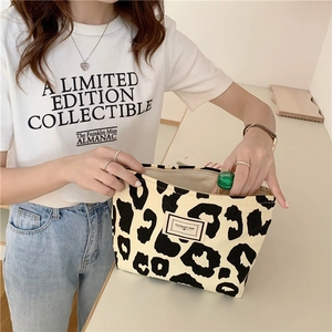 Detail of leopard print canvas tote bag featuring a vintage fabric patch and sturdy zipper
