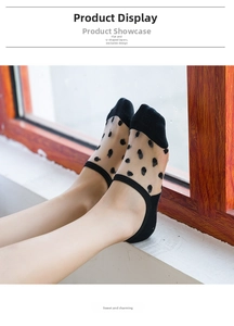 Detail of black polka dot sheer socks with reinforced toe on model feet