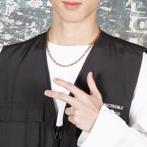 Close-up of golden stainless steel link chain necklace worn by a model in casual wear
