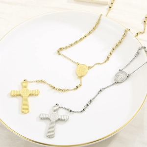 Close-up of gold and silver stainless steel 6mm rosary necklaces with cross pendants