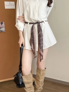 Détail d'une robe chemise blanche texturée ornée d'une ceinture en soie fleurie vintage